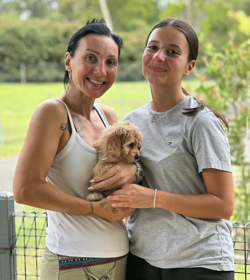 Photo of Claire Evans and Zoe Evans with their Cavoodle
