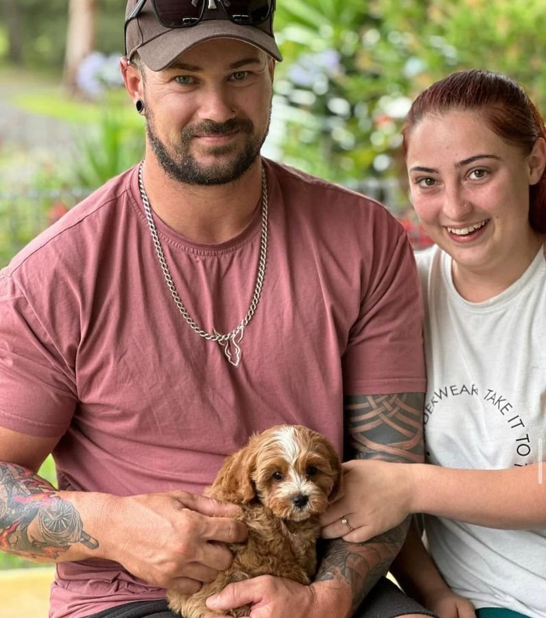 Photo of Daniel Hughes and Grace Miller with their Cavoodle