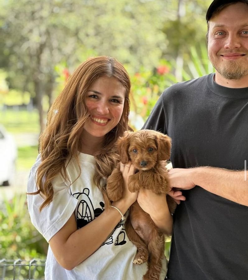 Photo of Ethan Brooks and Ruby Scott with their Cavoodle